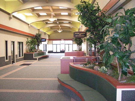 This is a picture of the interior of the Alpine Center, after the remodel was completed - rich earth tone surface treatments and curved planter boxes with bench seating create warm inviting spaces for people to gather