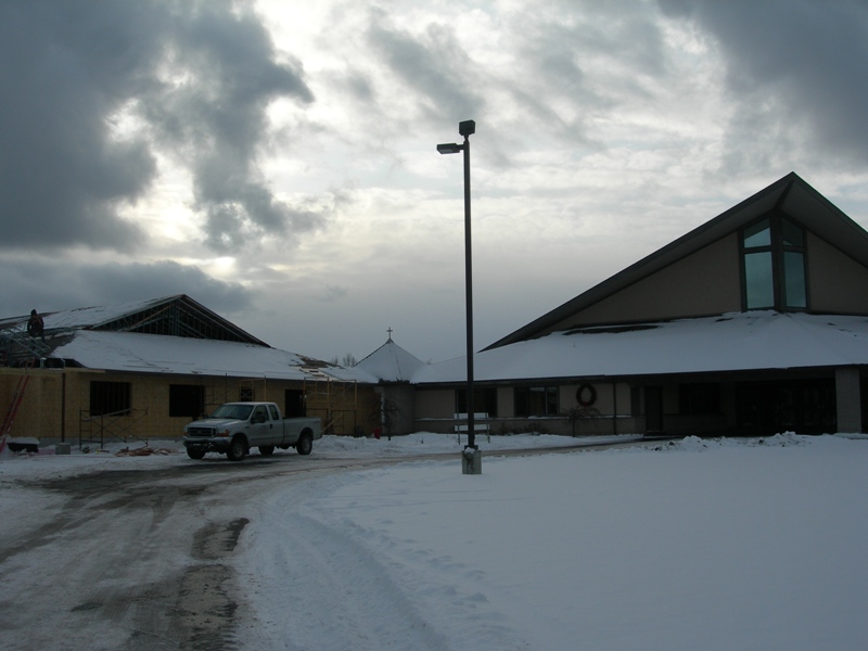 picture of front elevation shows Church Addition roofing being installed