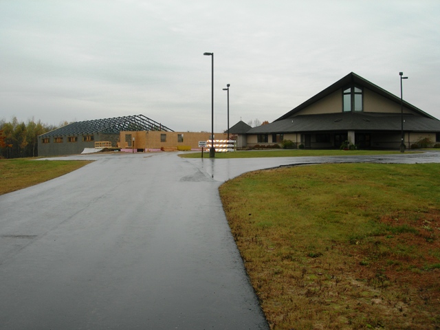 picture of addition under construction viewed from the front of the property - the steel roof trusses are visible above the concrete masonry walls