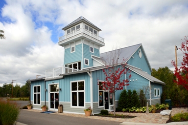 picture of Windjammer Marina in Alanson, Michigan - main entrance and beach side elevation - building has light blue siding, white trim and a grey metal roof