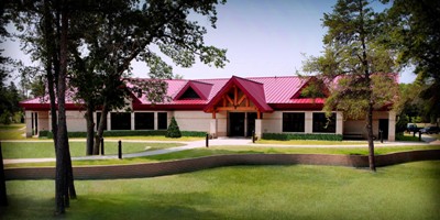 exterior picture of Dining Hall at Alpena Combat Readiness Training Center - building is light/tan masonry wall construction with red metal roof