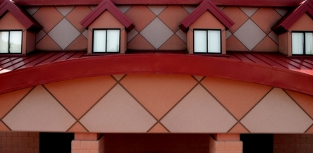 picture of masonry detail over main entrance to Fire/Crash/Rescue Station at Alpena Combat Readiness Training Center - curved metal 'eyebrow' over main entrance frames two-toned diagonal grid pattern wall construction