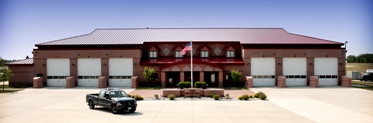 picture of a 22,000 SF state-of-the-art facility designed to provide fire protection to the structures on the base, and crash-rescue response to the airfield.  The building has 12 bays, accommodations for 20 full time personnel, along with a full time alarm room, day room, living quarters, training and conference spaces, and administrative offices.