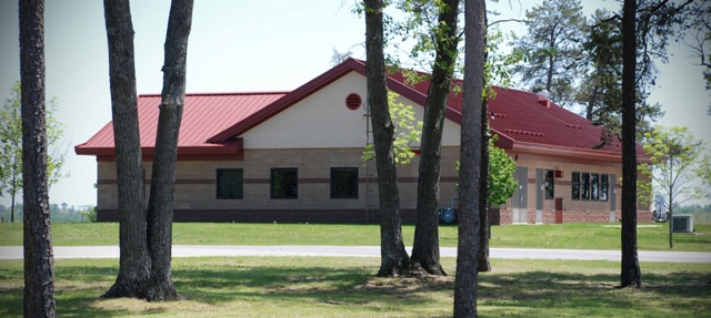 picture of Security Forces building at Alpena Combat Readiness Training Center - tan brick building with red masonry accent band, and red metal roof