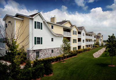 photo of Multi-Family Residential Development - Harborage Pointe Waterfront Condominiums in East Jordan, Michigan - this exterior photo shows the elevation that is visible from the road side of the development, with the lake just visible on the other side of the building