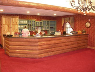 interior photo of Freighter View Assisted Living Facility in Sault Ste. Marie, Michigan - front desk/reception/nurses' station - built of horizontal logs with stone counter, log beam in celing, custom built-ins and file storage