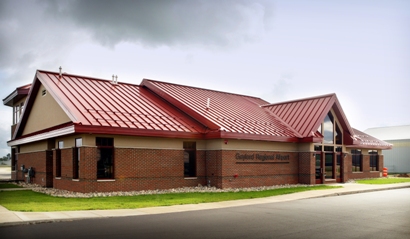 Picture of Exterior of Gaylord Regional Airport General Aviation Terminal, parking lot elevation - the control tower is just visible on the back side of the building