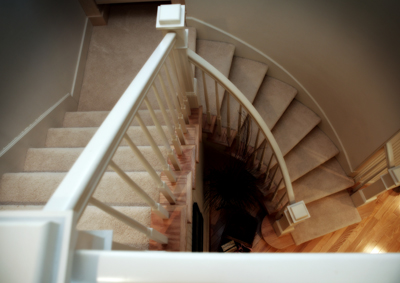 picture of Manuka Lake home - this interior photo is taken from the top landing for the custom staircase - the lower set of steps is slightly rounded as it follows the curvature of the wall