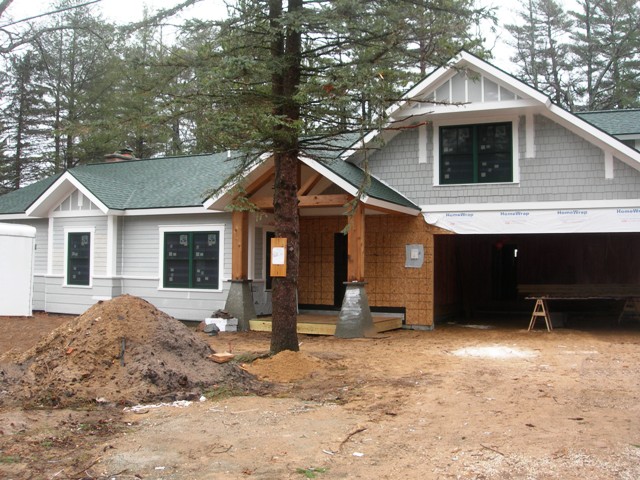 Lake Margrethe custom home with green roof and window trim, two-tone grey siding with white trim