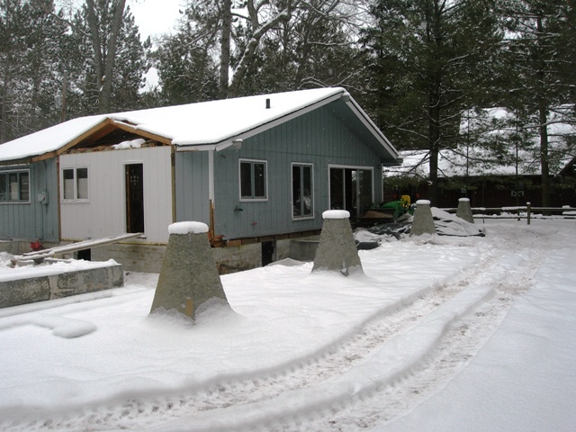 demolition of the existing structure continues, and the concrete piers for the new construction have been set in place