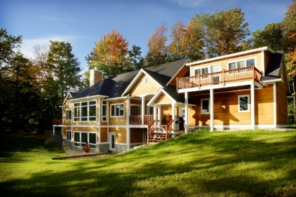 exterior photo of custom waterfront home on Dixon Lake - this photo is the lakeside elevation with the garage (and bonus room with balcony) on the hill and the home progressing down the hill