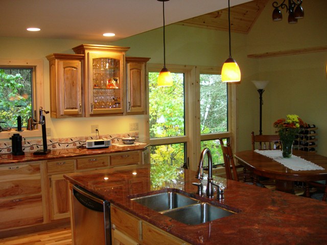 interior photo of the custom kitchen looking toward the open dining area, giving a glimpse of wood planking in the high ceilings above