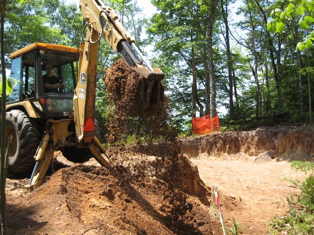 picture of backhoe with a shovel full of dirt