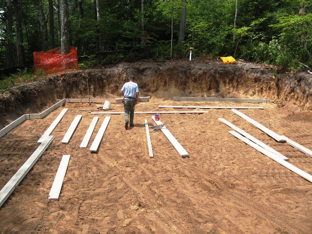 picture of man walking through cleared site with formwork