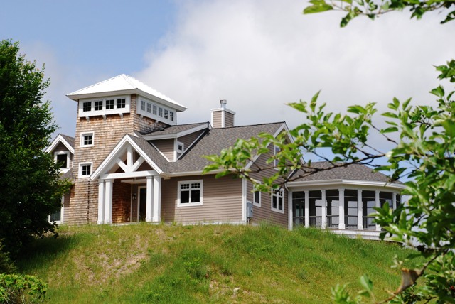 picture of custom home with tower and screened oval porch overlook