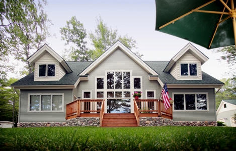 custom waterfront home on East Twin Lake, Lewiston MI - this photo is of the lakeside elevation, taken while standing on the beach looking straight up the steps to the deck