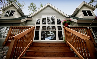 custom waterfront home on East Twin Lake in Lewiston MI - this exterior photo is of the lakeside elevation, taken from the foot of the steps leading up to the deck