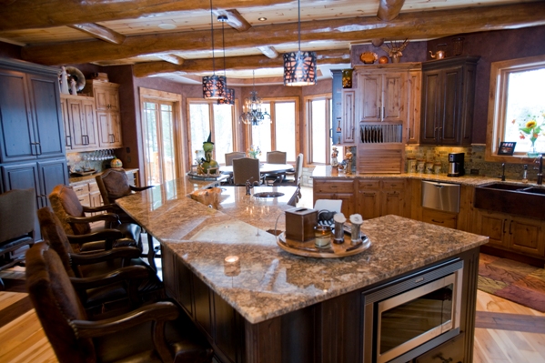 photo taken from inside the gourmet kitchen, looking over the center island/seating area with dining room beyond