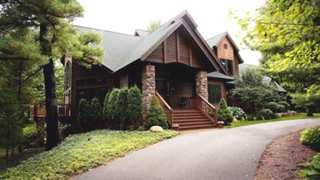 picture of golf course home - this exterior photo is of the main entry covered porch with stone pillars - notice the detail on the front of the porch