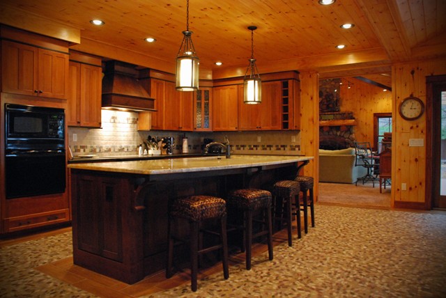 interior photo of gourmet kitchen with wood plank ceiling and pebble-stone mosaic floor