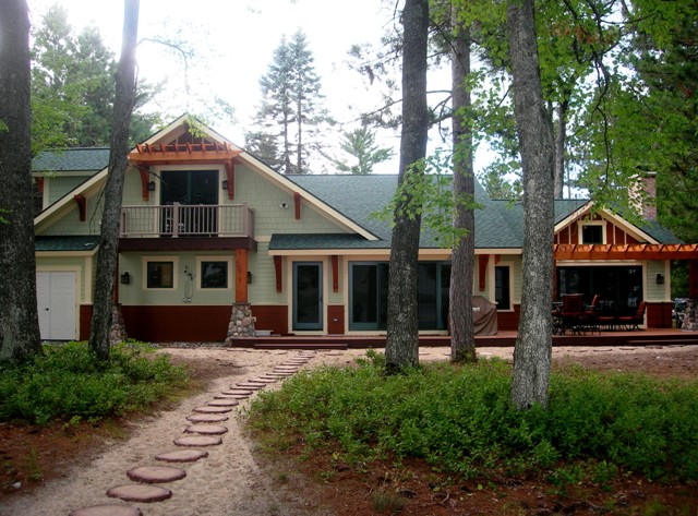 Lake Margrethe custom home lakeside exterior, green and cedar siding, white trim and fieldstone accents