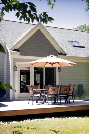 picture of custom home at Mountain Lake Golf Club -  this exterior photo is of the home's rear elevation showing grey siding and architectural shingles, white trim and french doors opening onto a wood deck