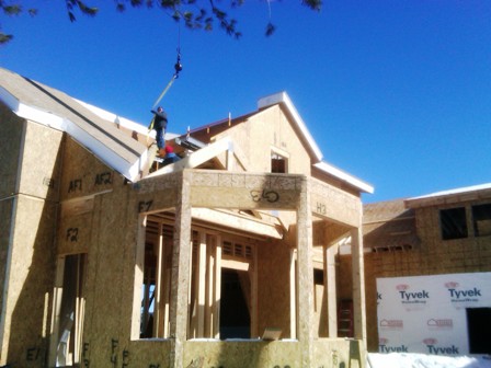 picture of workmen installing roof trusses on custom home being built on Otsego Lake in Gaylord, Michigan