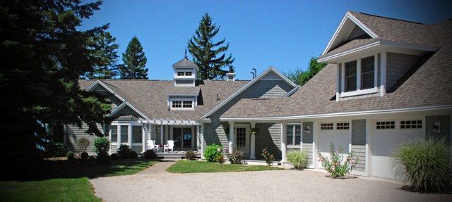 picture of roadside entry from driveway, main entrance and garage